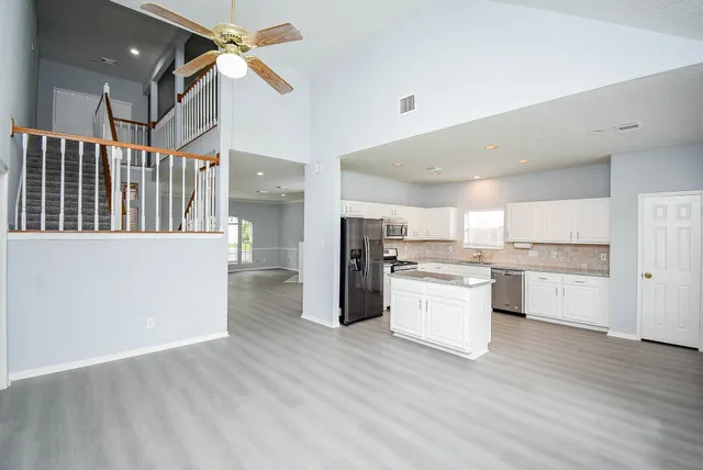 a kitchen with a refrigerator and white cabinets
