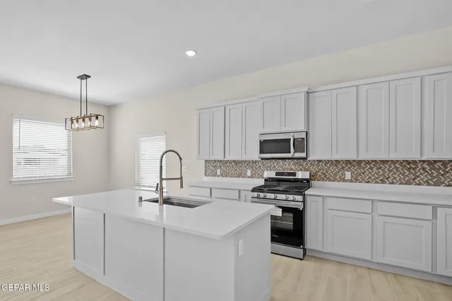 a kitchen with white cabinets and appliances