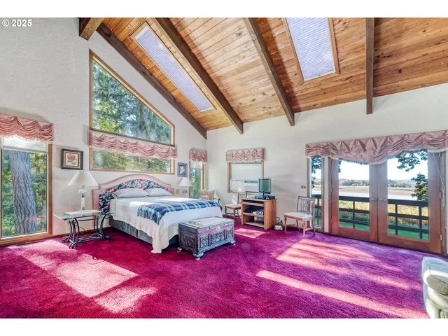 a bedroom with furniture and a large window