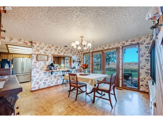 a dining room with furniture a chandelier and wooden floor