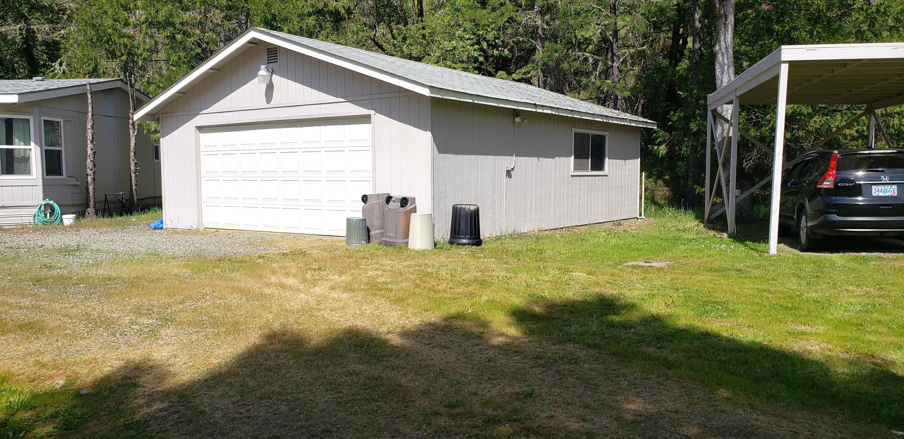 7055 Takilma Road Cave Junction, OR 97523 - Photo 4 of 26 3 car garage with some shelving inside