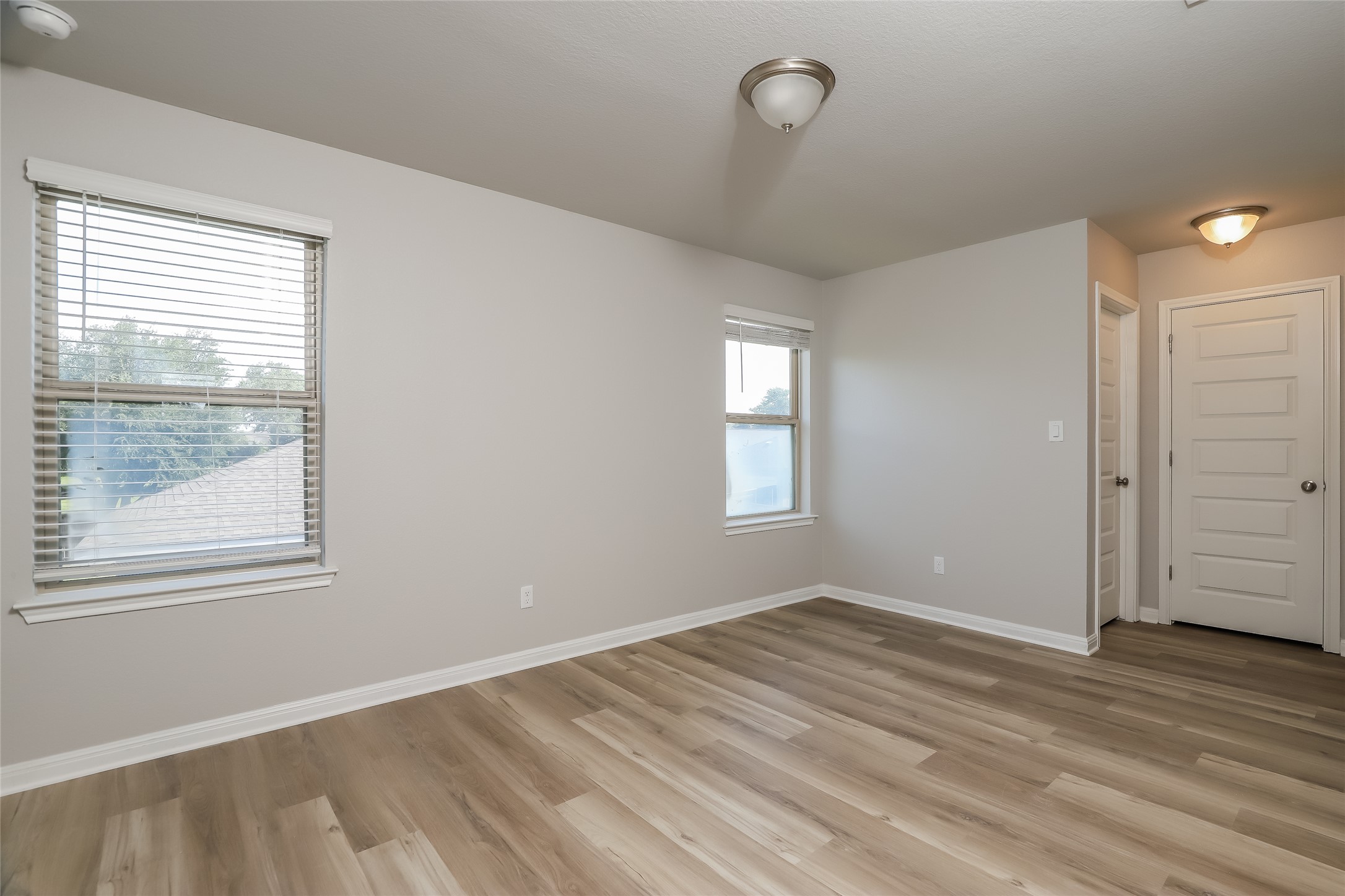 2724 Juniper Woods Road Leander, TX 78641 - Photo 14 of 21 Naturally illuminated bedroom with durable wood flooring and ample natural light from multiple windows.