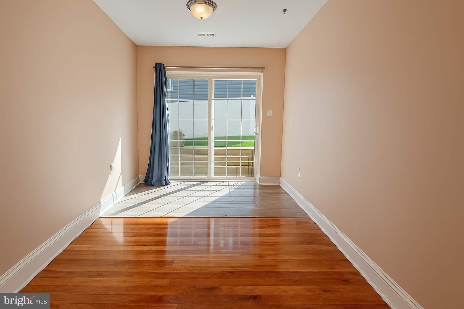 5544 Old Colony Court White Plains, MD 20695 - Photo 11 of 24 a view of an empty room with wooden floor and a window