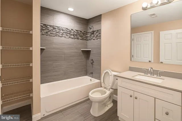 a bathroom with a bathtub shower sink vanity and toilet