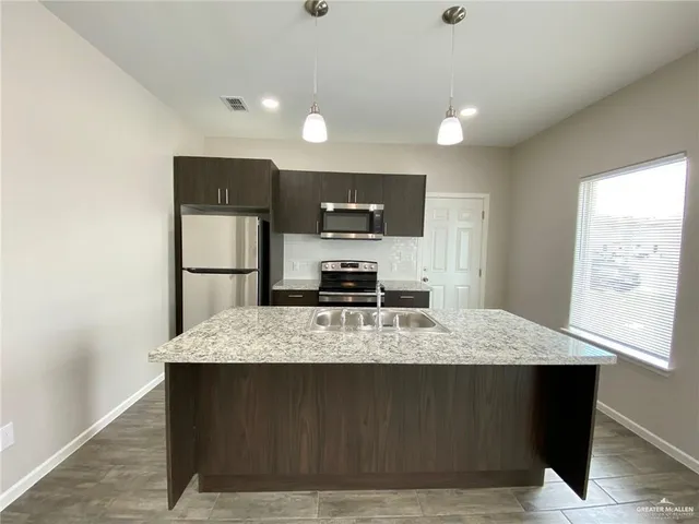 a large kitchen with kitchen island a counter space and wooden floor