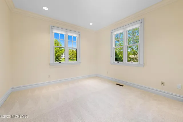 a bed sitting in a spacious bedroom next to a window
