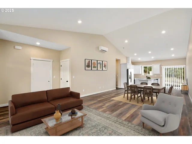 a living room with furniture and kitchen view with a large window