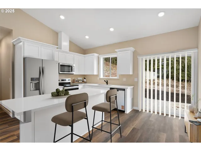 a view of kitchen with refrigerator stove dining table and chairs