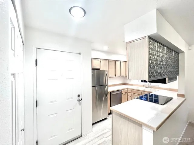 a kitchen with stainless steel appliances a refrigerator sink and white cabinets