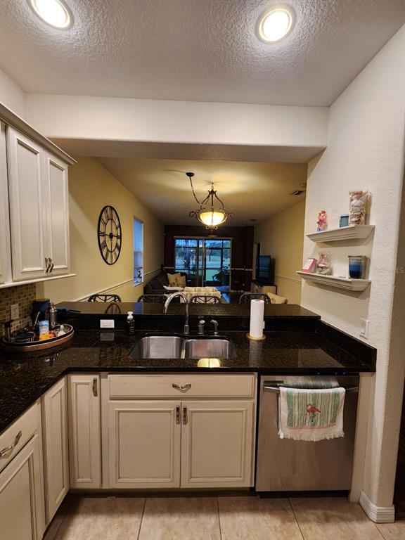 9027 Stone Harbour Loop Bradenton, FL 34212 - Photo 3 of 20 a kitchen with granite countertop a sink cabinets and stainless steel appliances