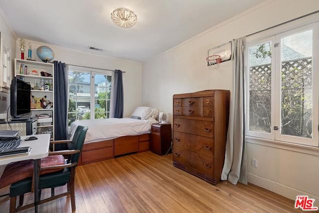 a bedroom with a bed and wooden floor