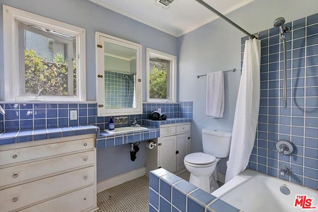 a bathroom with a sink toilet a mirror and shower