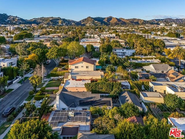 an aerial view of residential houses with outdoor space and trees