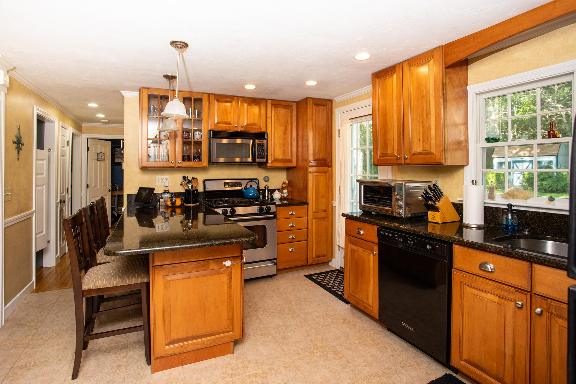 150 Old Mill Road Marstons Mills, MA 02648 - Photo 5 of 29 a kitchen with stainless steel appliances granite countertop a stove top oven a sink dishwasher a refrigerator and cabinets with wooden floor