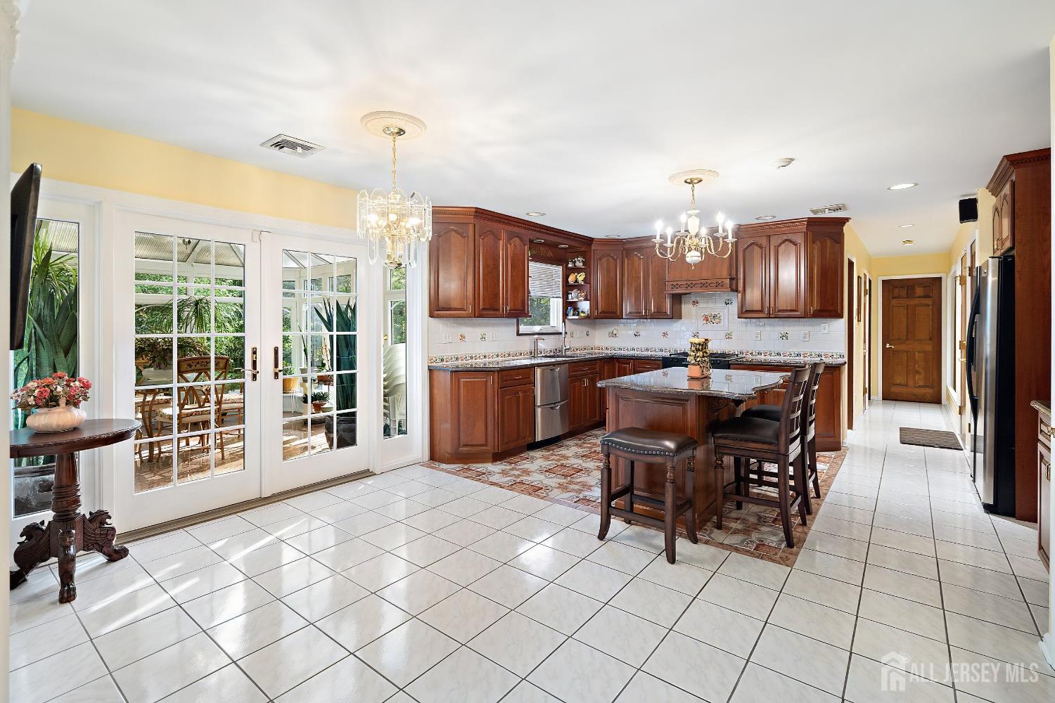 3 Anthony Avenue Edison, NJ 08820 - Photo 13 of 41 a kitchen with stainless steel appliances a stove a refrigerator a sink a dining table and chairs with wooden floor