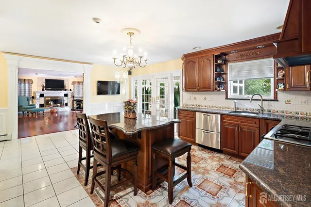 a large kitchen with stainless steel appliances kitchen island granite countertop a sink and cabinets