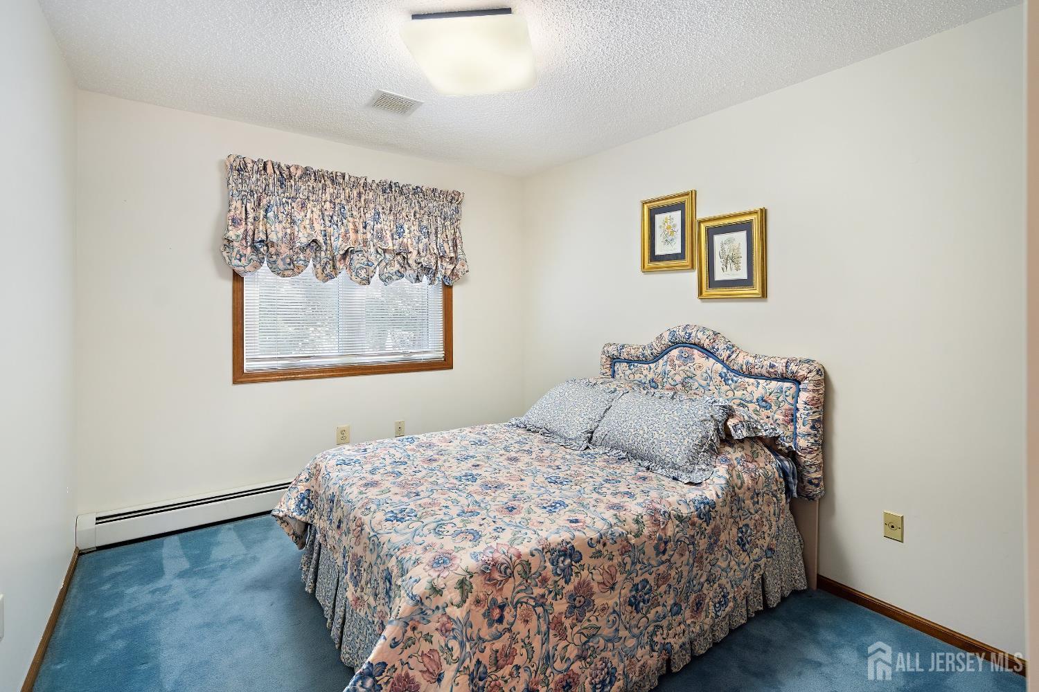 3 Anthony Avenue Edison, NJ 08820 - Photo 24 of 41 a bedroom with a large bed and a painting on the wall