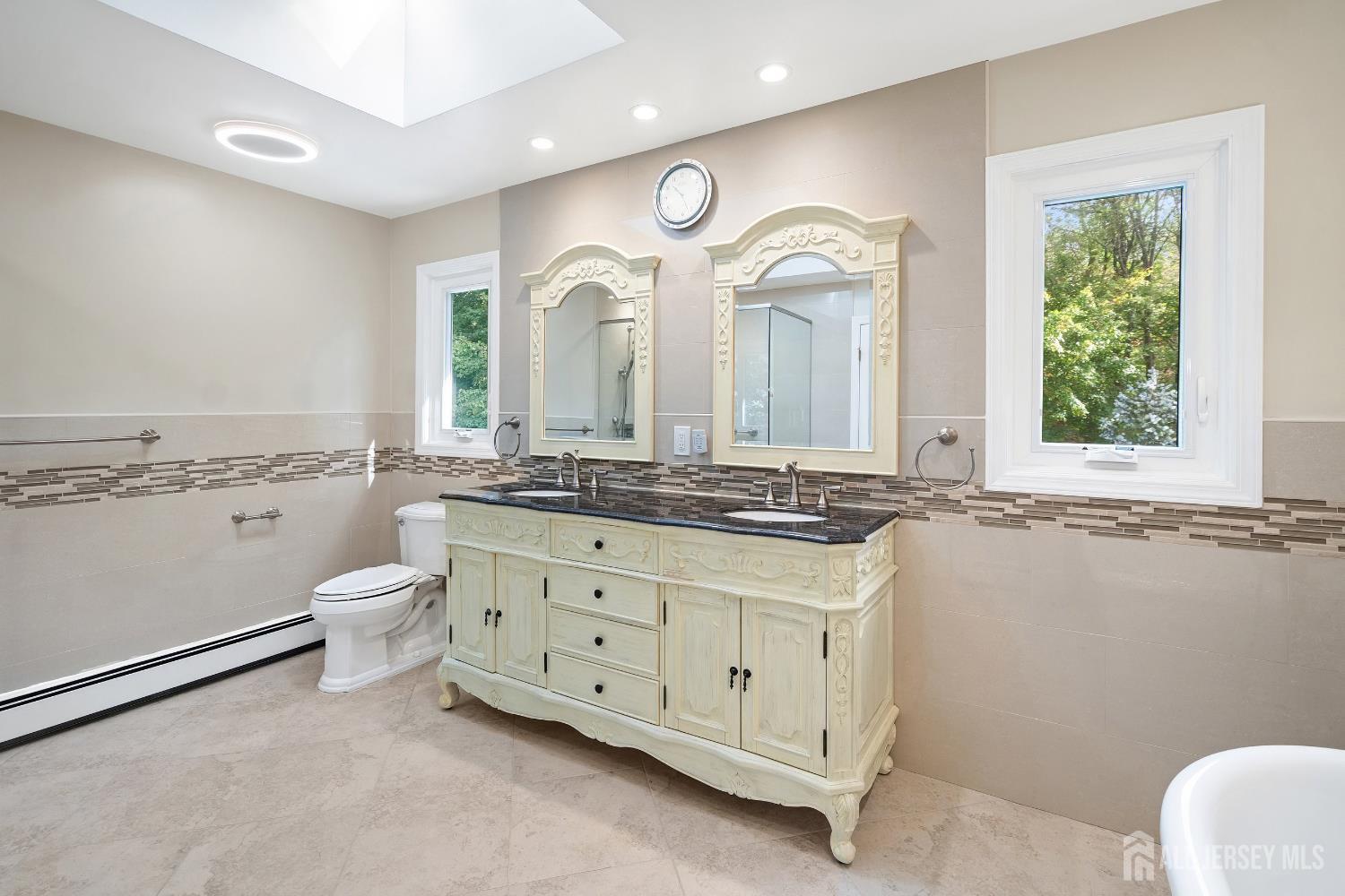 3 Anthony Avenue Edison, NJ 08820 - Photo 27 of 41 a bathroom with a granite countertop toilet a double vanity sink a mirror and a window