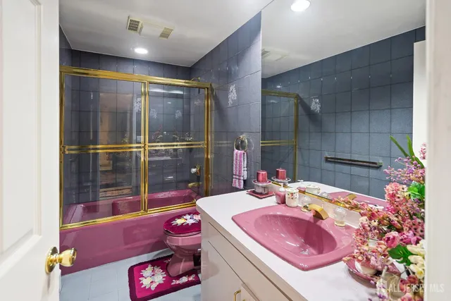 a bathroom with a sink mirror and tub