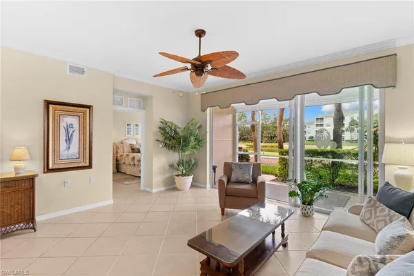a living room with furniture a chandelier and a glass door