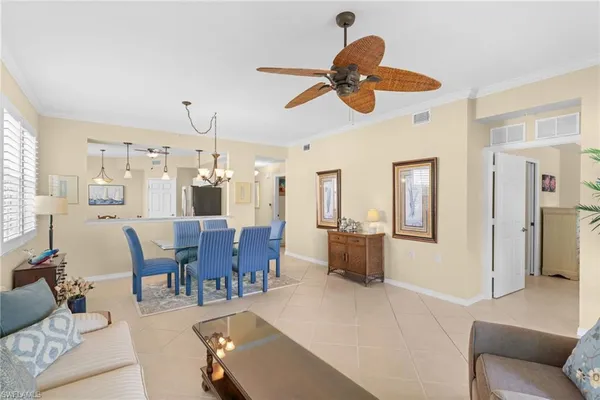 a living room with furniture kitchen view and a chandelier