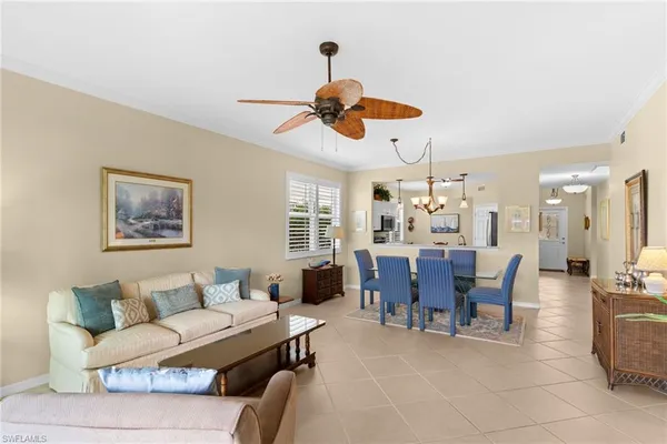 a living room with furniture a chandelier and a dining table
