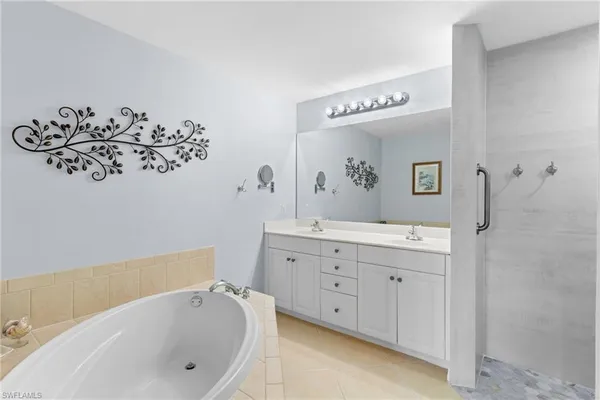 a bathroom with a bathtub sink and mirror