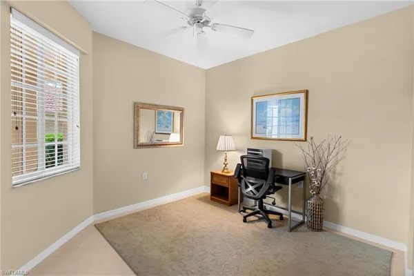 a view of a workspace with furniture and a window
