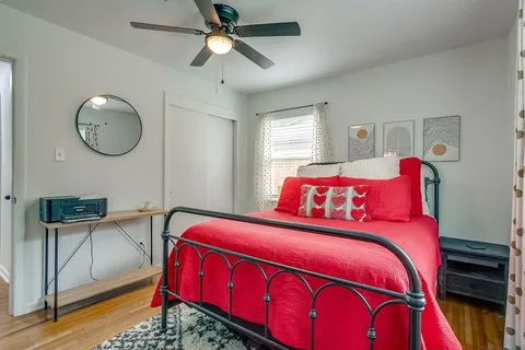 a bedroom with bed and two windows