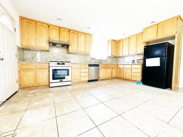 a kitchen with stainless steel appliances a stove a sink and a refrigerator
