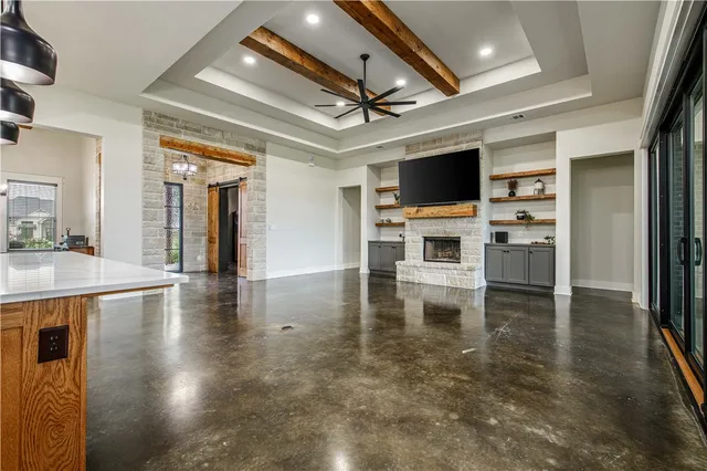 a living room with stainless steel appliances furniture a fireplace and a flat screen tv