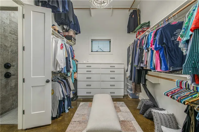 a view of walk in closet with clothes and shoes
