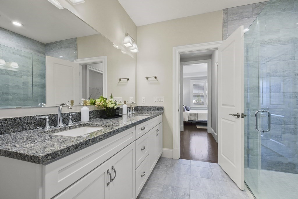 9 Eagle Lane, Unit 9 Framingham, MA 01701 - Photo 17 of 42 a bathroom with a granite countertop sink and a mirror