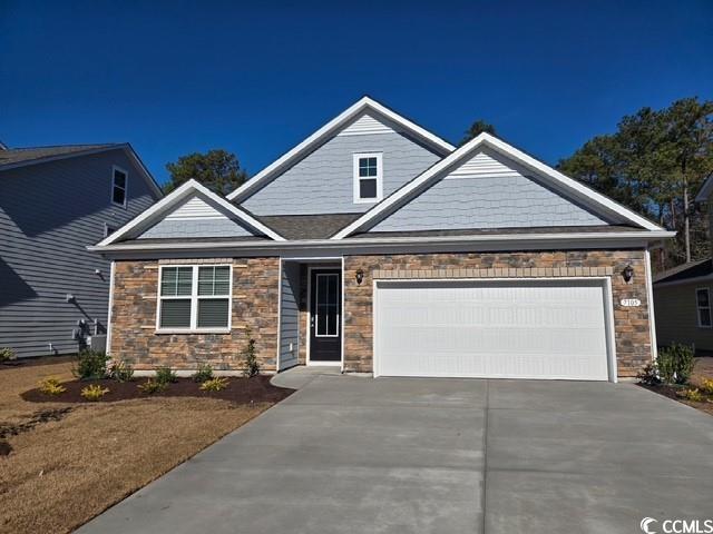 7105 Shooting Star Way Myrtle Beach, SC 29579 - Photo 1 of 26 Craftsman-style house featuring stone siding, driveway, and a garage