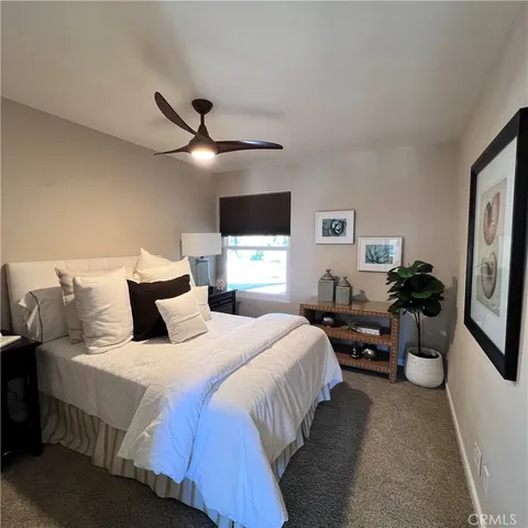 a bedroom with bed couches and a flat tv screen