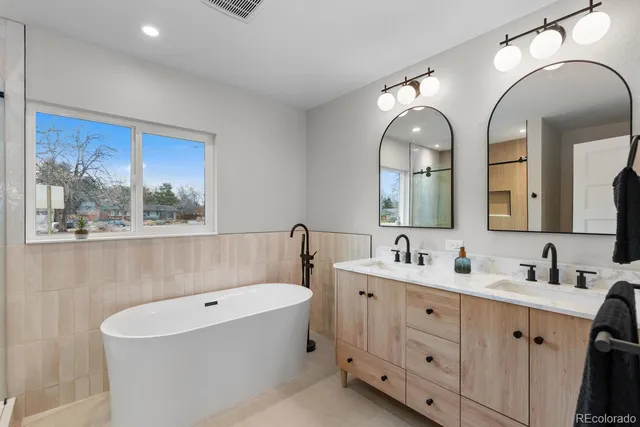 a bathroom with double vanity sinks and a mirror