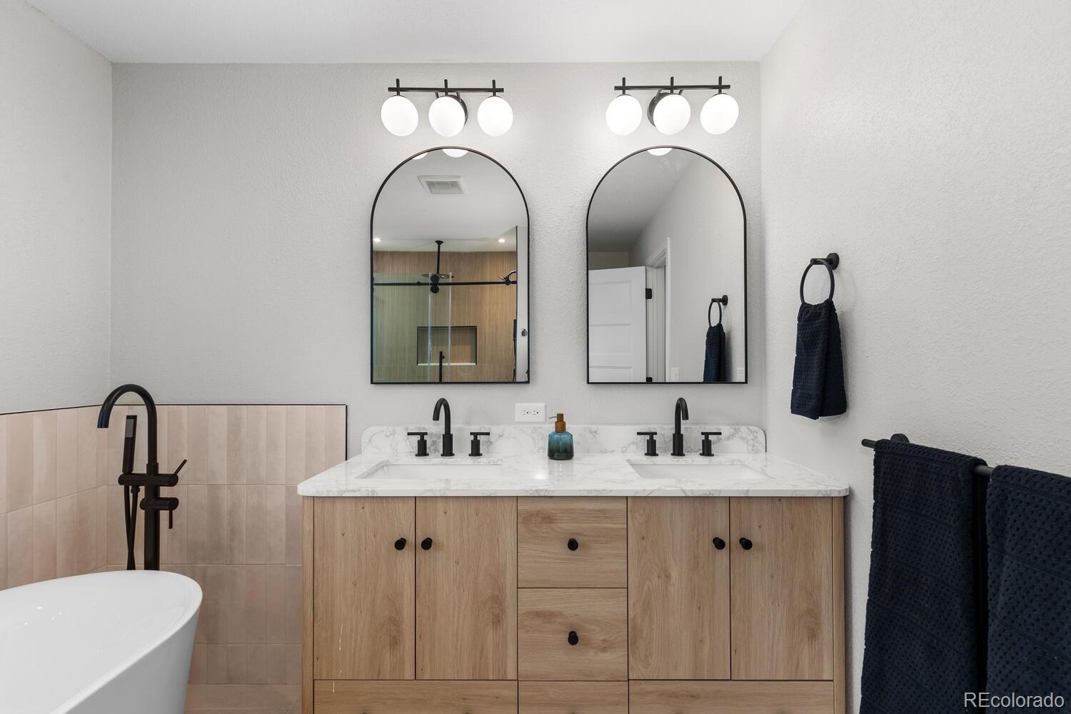 1711 South Forest Street Denver, CO 80222 - Photo 24 of 44 a bathroom with double vanity sinks and a mirror