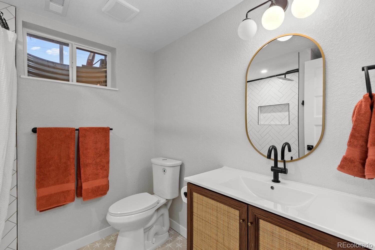 1711 South Forest Street Denver, CO 80222 - Photo 31 of 44 a bathroom with a toilet sink and mirror