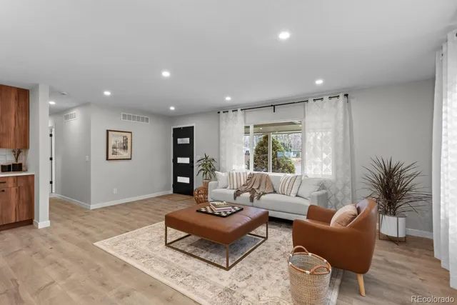 a living room with furniture kitchen view and a potted plant