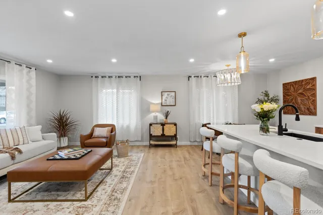 a living room with furniture and a dining table with kitchen view