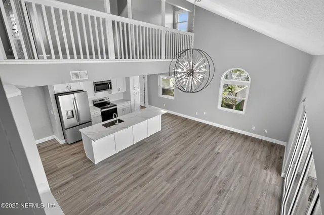 a kitchen with kitchen island a counter top space appliances and cabinets
