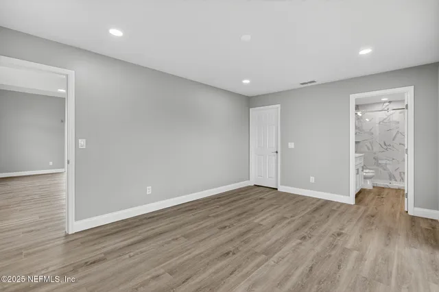 a view of an empty room with wooden floor