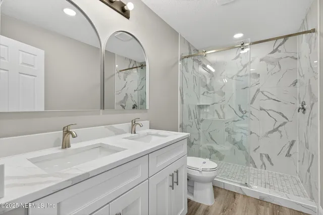 a bathroom with a granite countertop sink a toilet and a mirror