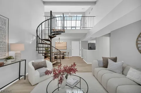 a living room with furniture stairs and a chandelier