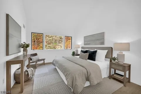 a bedroom with a bed a lamp on table and a window