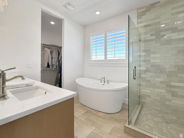 916 Rocky Mountain Way Elk Ridge, UT 84651 - Photo 23 of 54 Bathroom featuring a shower stall, a soaking tub, recessed lighting, a walk in closet, and double vanity