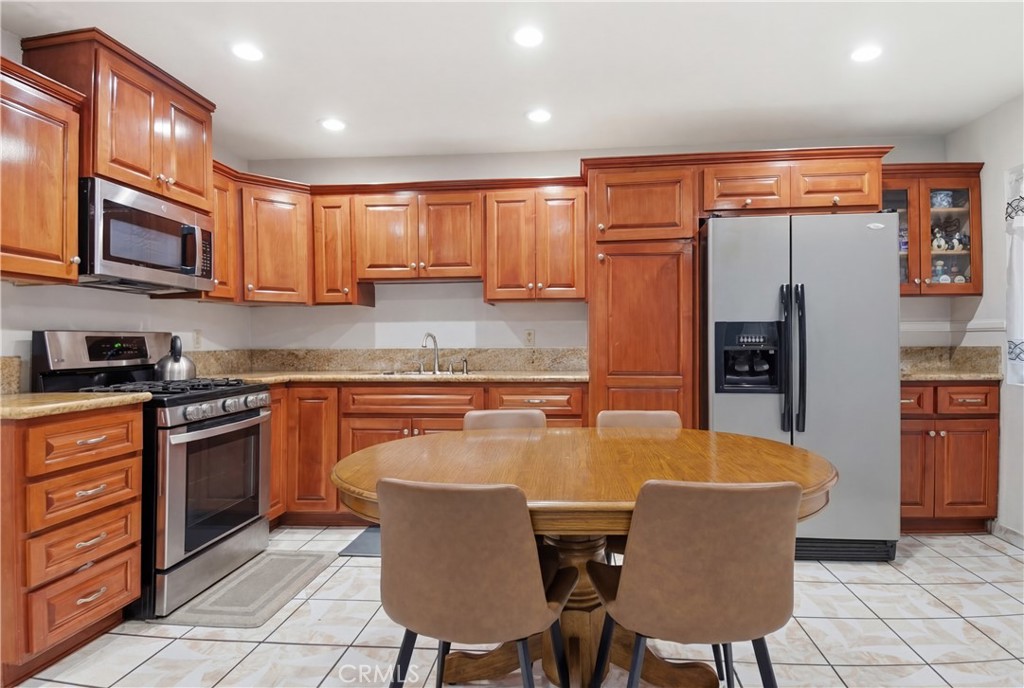 3301 Santa Fe Avenue, Unit 49 Long Beach, CA 90810 - Photo 5 of 26 a kitchen with stainless steel appliances granite countertop a kitchen island a table and chairs