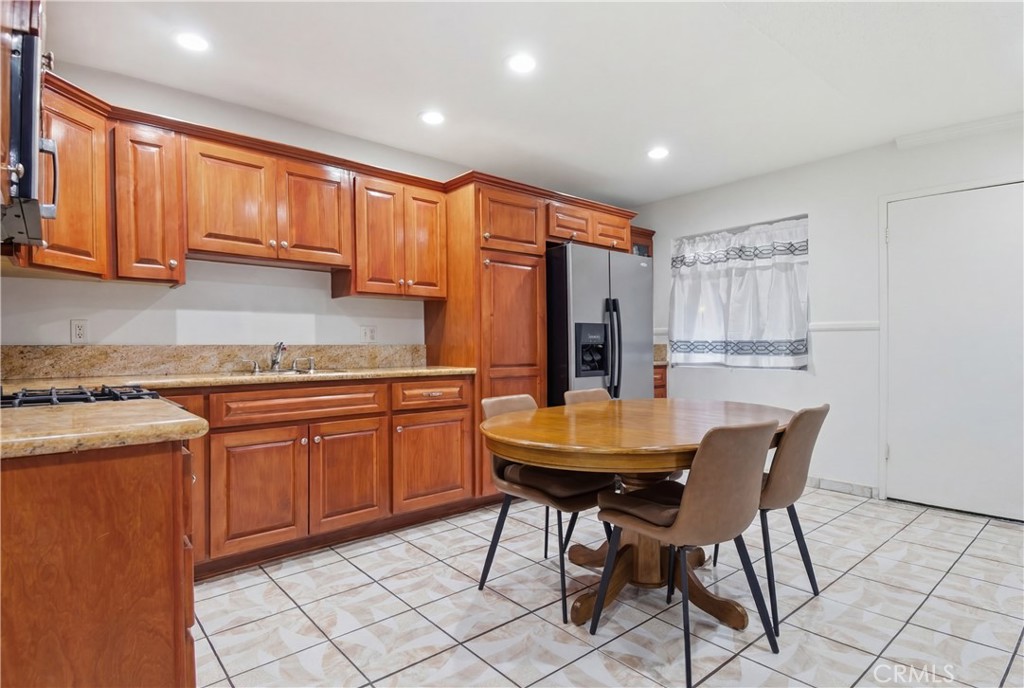 3301 Santa Fe Avenue, Unit 49 Long Beach, CA 90810 - Photo 10 of 26 a kitchen with stainless steel appliances granite countertop a table chairs sink and cabinets