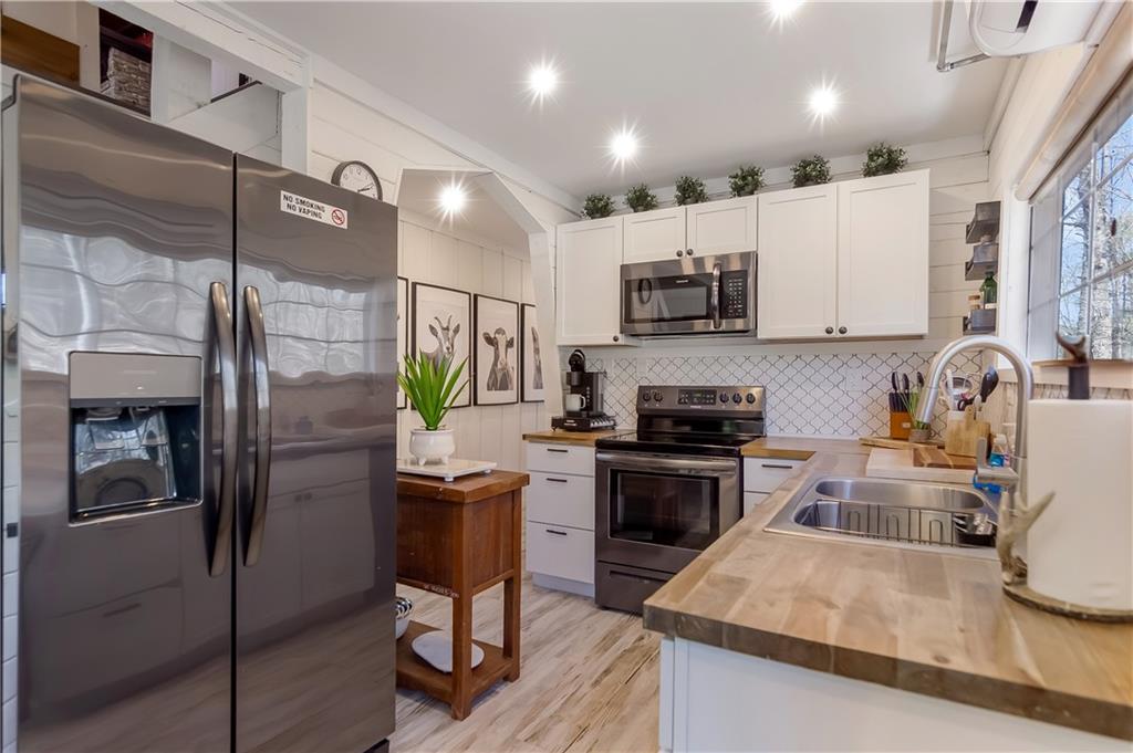 2308 Carver Mill Road Talking Rock, GA 30175 - Photo 10 of 33 a kitchen with stainless steel appliances granite countertop a refrigerator a stove a sink and a microwave