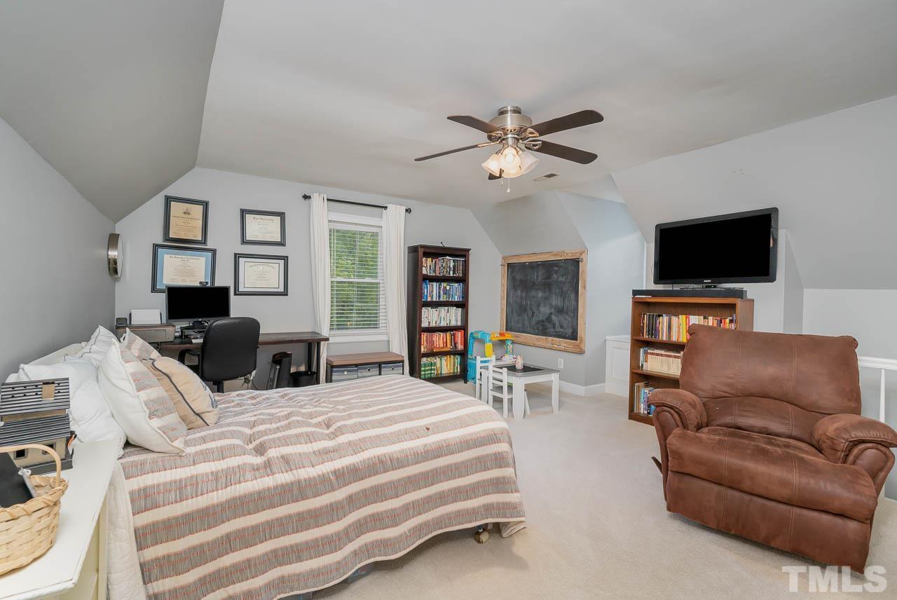 108 Donna Place Cary, NC 27513 - Photo 24 of 30 a bedroom with a bed a flat screen tv and a couch